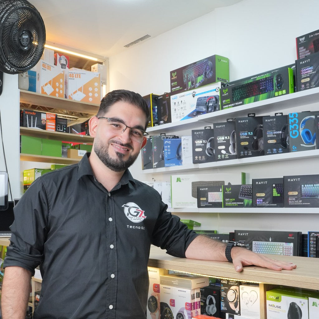 Yeison Gomez en el local real de Tecno Gz en Rionegro, junto a la vitrina de accesorios
